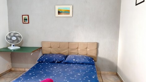 Imagem do quarto com a cama de casal e ao lado uma mesinha para homeoffice