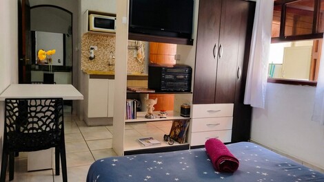 Cama e guarda roupas e a tv de 32" na frente, e logo mais do outro lado deste armário, a cozinha.