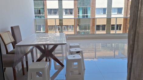 Varanda ampla com espaço gourmet e vista lateral para a orla.