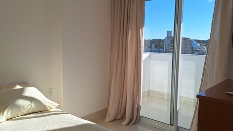 Quarto com cama de casal, 1 ventilador de mesa e 1 ventilador de teto