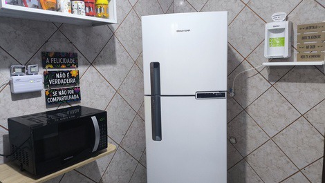 Geladeira com freezer e microondas na cozinha