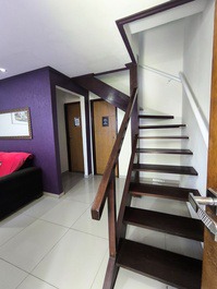 Sala de estar com escada para acesso aos ambientes superiores 