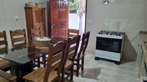 Cozinha equipada com fogão novo, mesa de jantar e todos utensílios