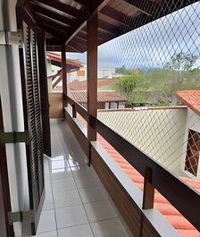 House with balcony and barbecue in gated community.