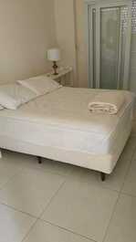 Suíte master com criados mudo, abajours, tv à cabo, armários, split e varanda em l