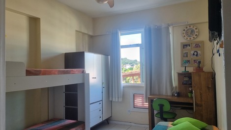 Quarto de solteiro com 4 camas, tv, ventilador, mesa de trabalho. 