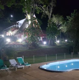 Piscina com casa ao fundo