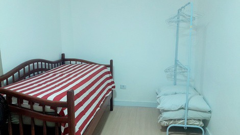 Cama de solteiro e arara para organizacao das roupas.