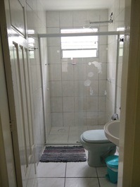 Banheiro com box de vidro.