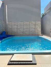 Casa pequeña con piscina y barbacoa.