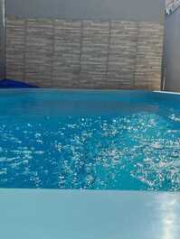 Casa pequeña con piscina y barbacoa.