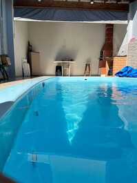 Casa pequeña con piscina y barbacoa.