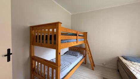 O quarto possui uma beliche e uma cama de casal