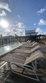 Espreguiçadeiras  na beira da piscina 