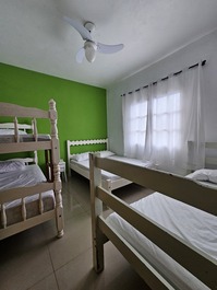 Quarto com ventilador, beliche e duas camas de casal.
